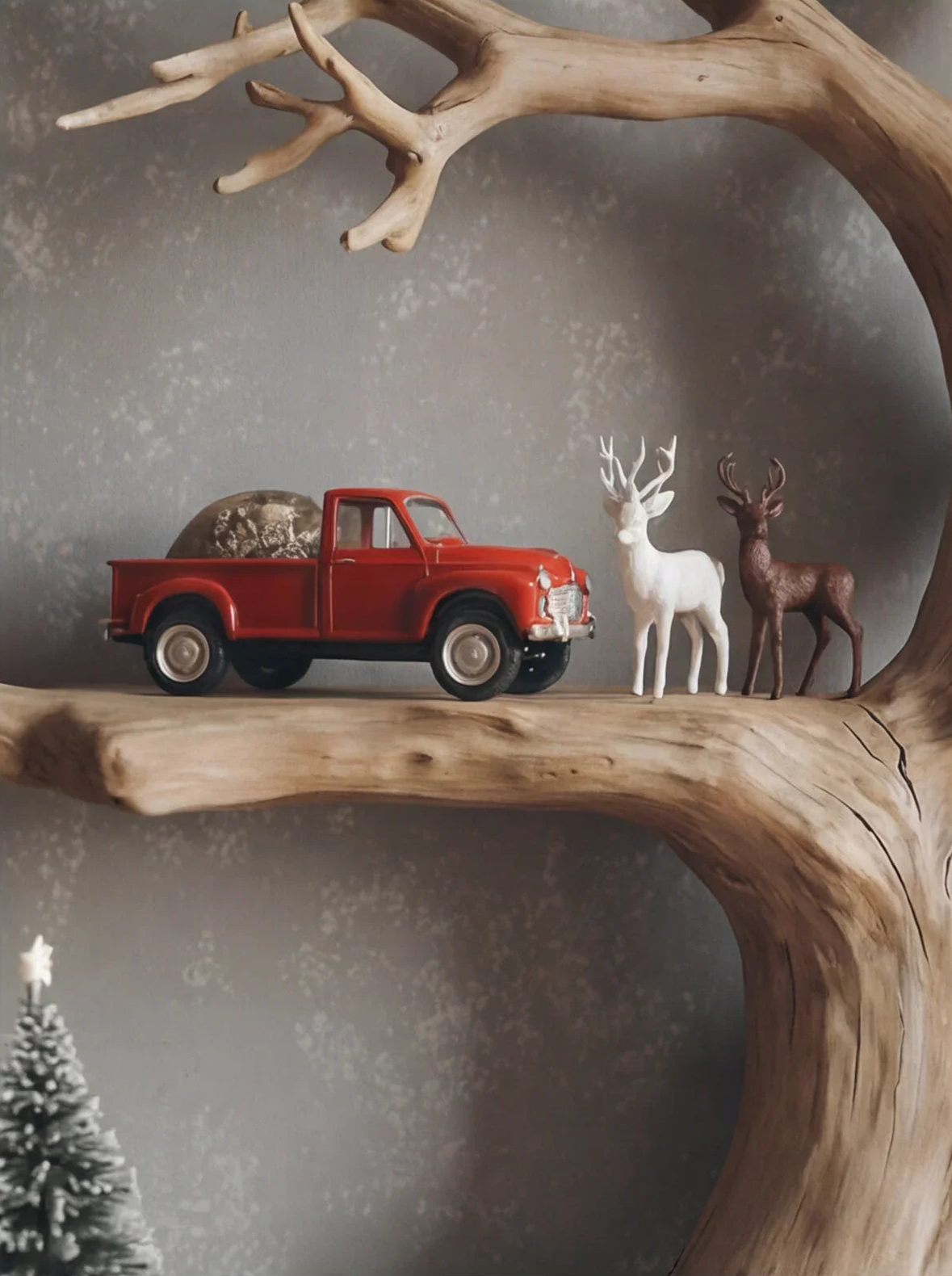 Rustic tree branch shelf with red toy truck and decorative deer figurines