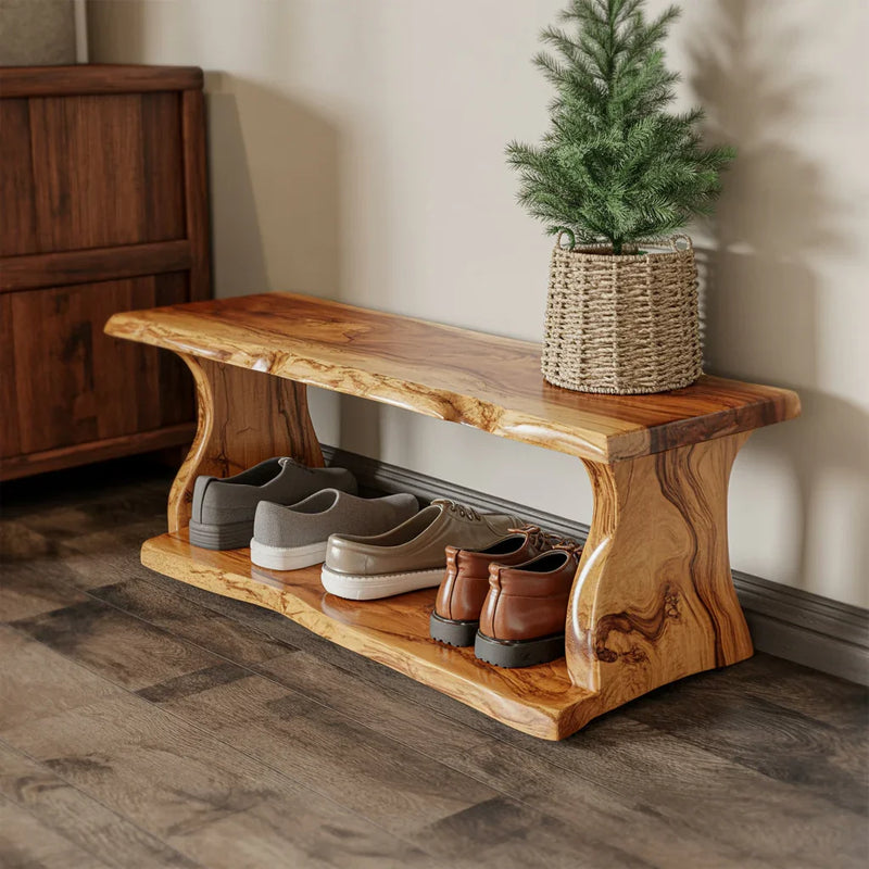 Solid wood shoe bench with natural grain, holding three pairs of shoes and a small pine plant in woven basket