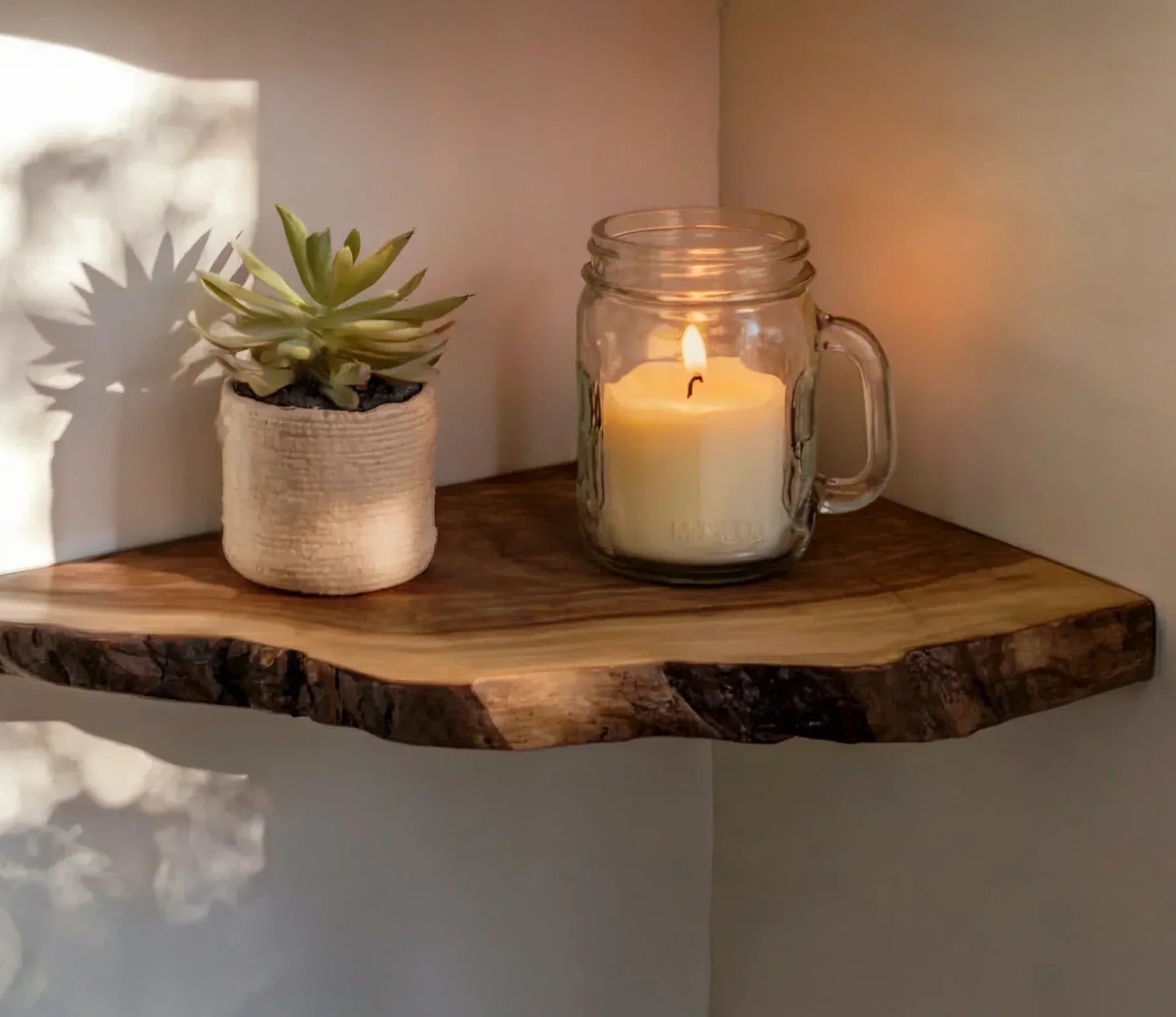 Live edge floating wood shelf with potted succulent and mason jar candle in minimalist corner.