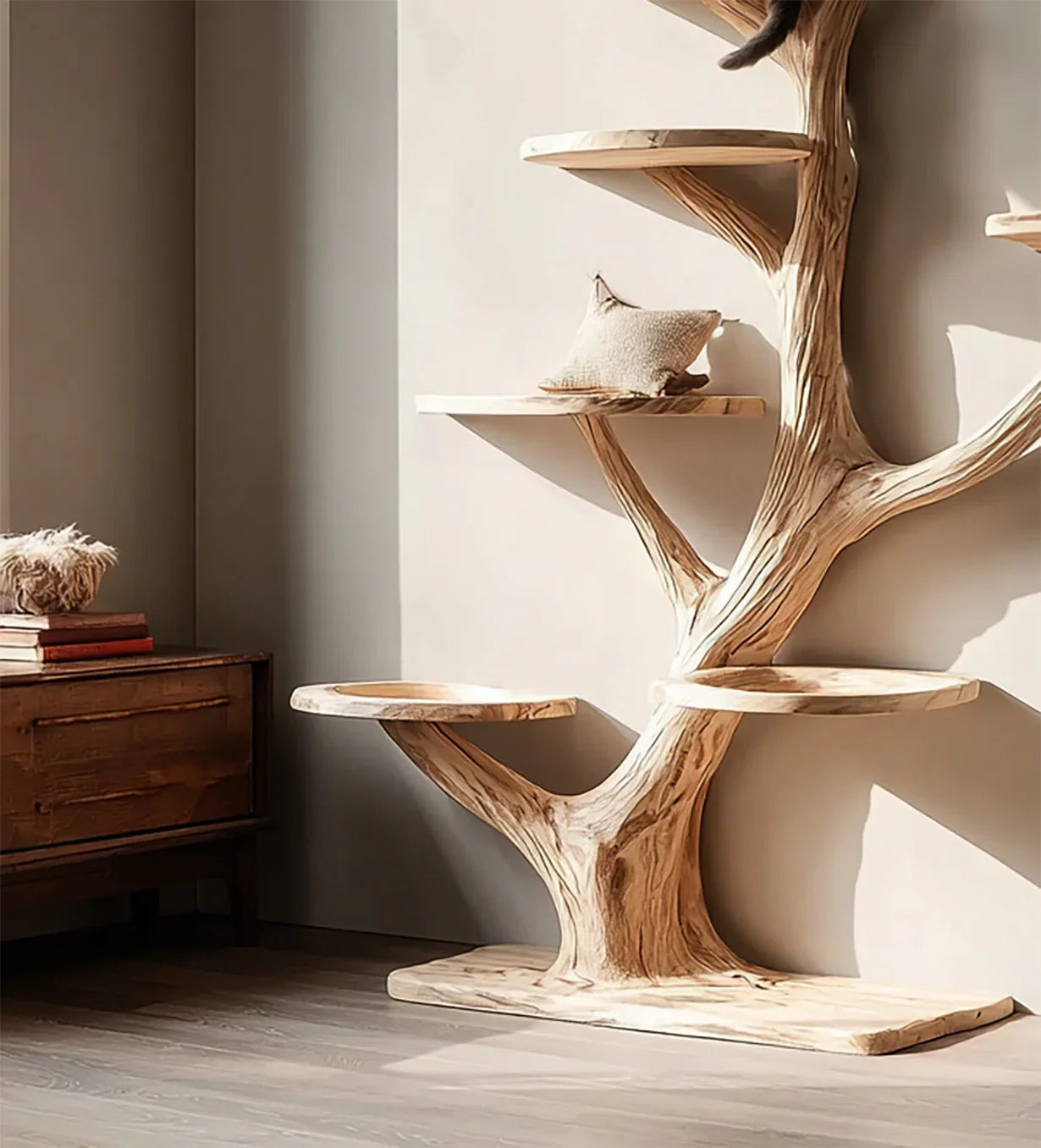 Natural wood cat tree with multiple platforms and a beige cushion in a sunlit room