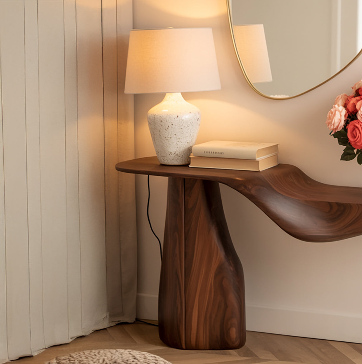 Live edge solid wood console table with sculpted base, lamp, books, and flowers in modern room