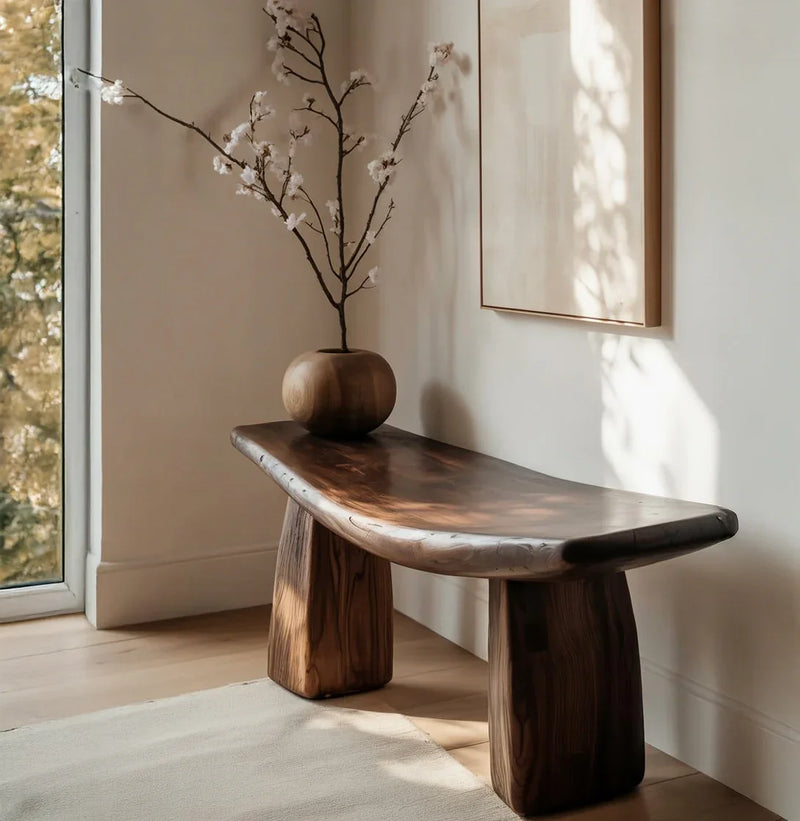 Solid wood live edge bench in a modern interior with a wooden vase and floral branches