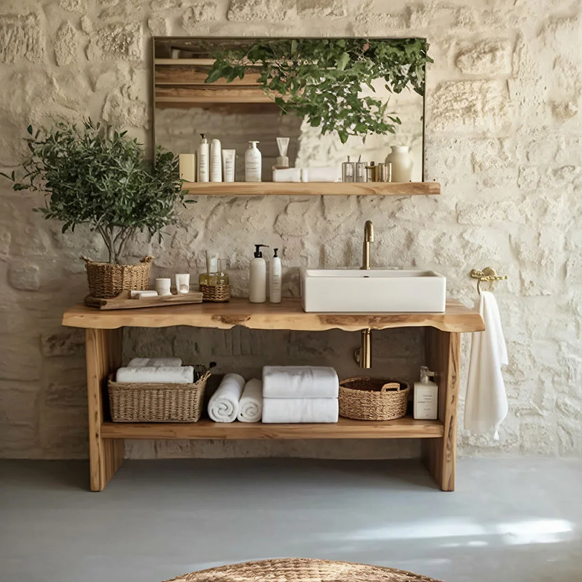 Solid wood live edge bathroom vanity with vessel sink, stone wall, baskets, towels, and greenery.