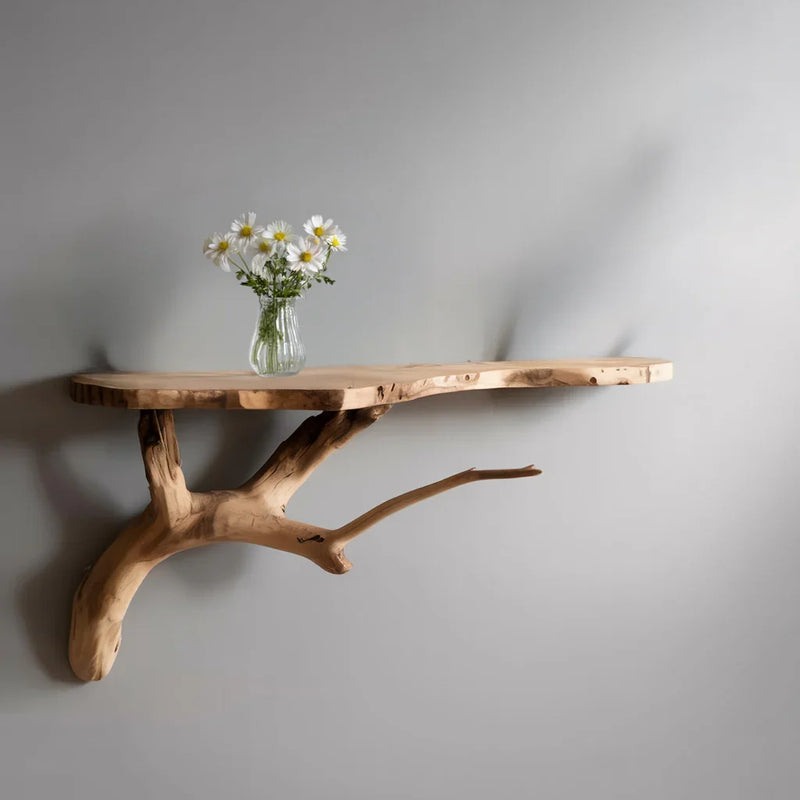 Live edge floating wood shelf with a branch support and vase of daisies against a gray wall