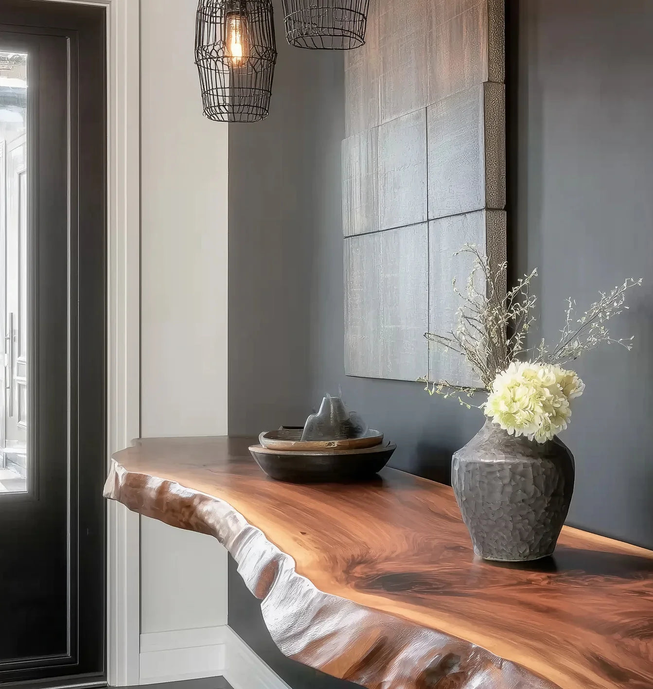 Modern interior featuring a live edge wood console table with decorative vase and pendant lights