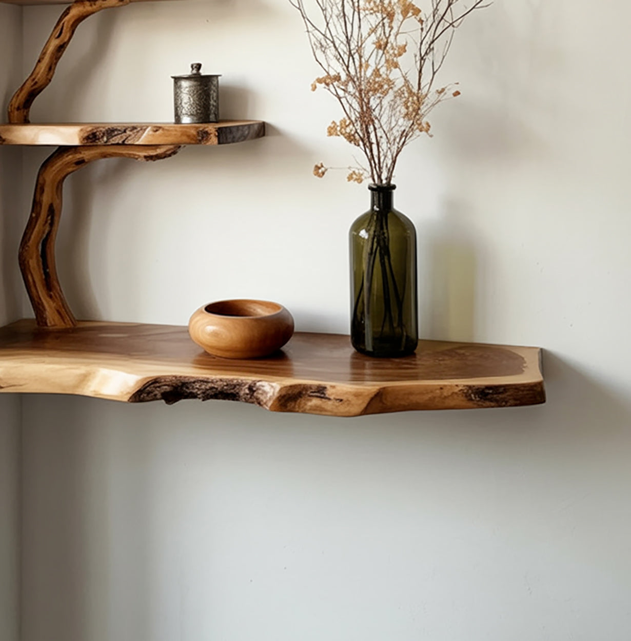 Natural live edge wooden shelves with dried flowers in green glass vase and wooden bowl on white wall