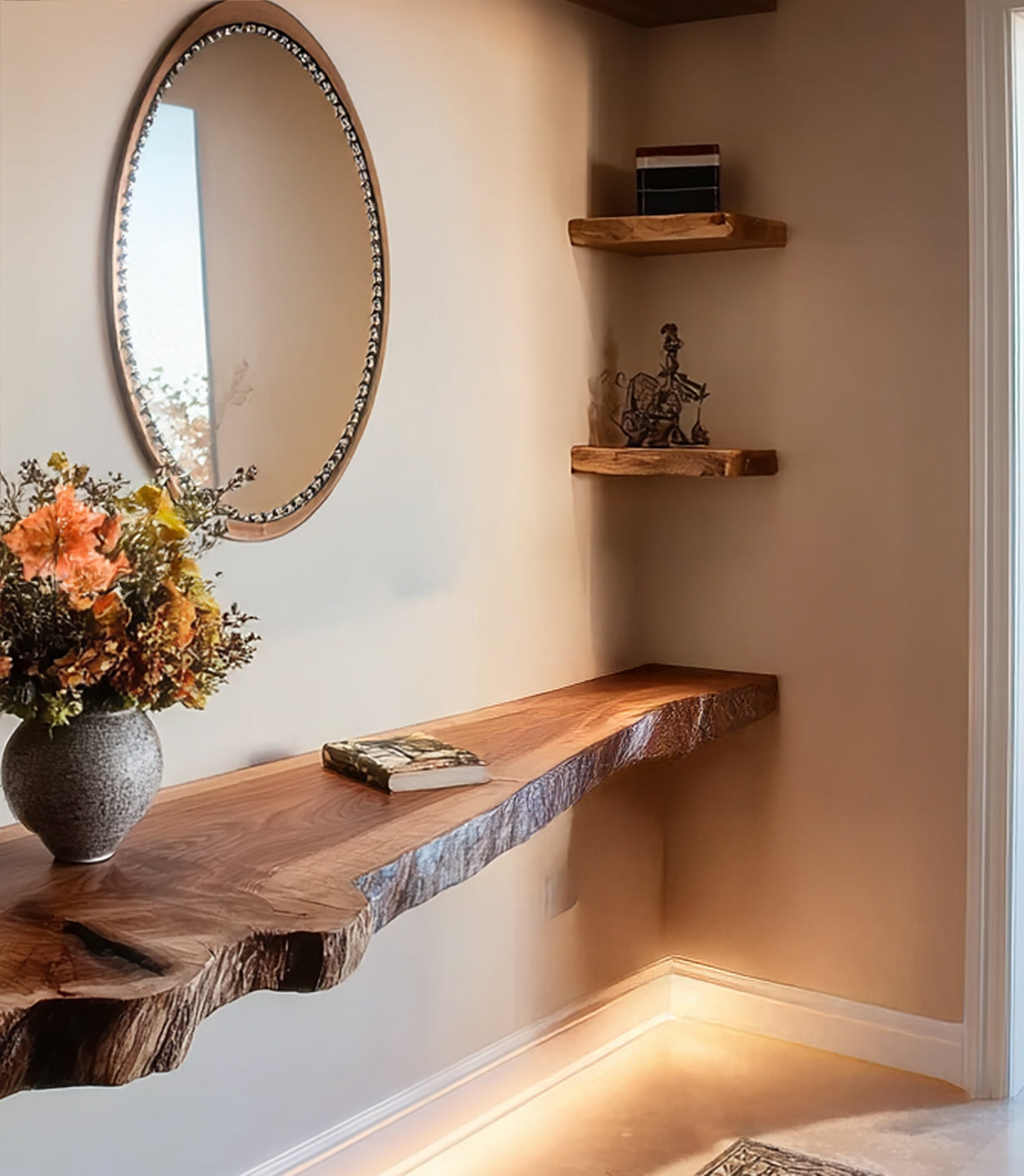 Rustic live edge wooden floating desk with decorative flowers, book, oval mirror, and corner shelves