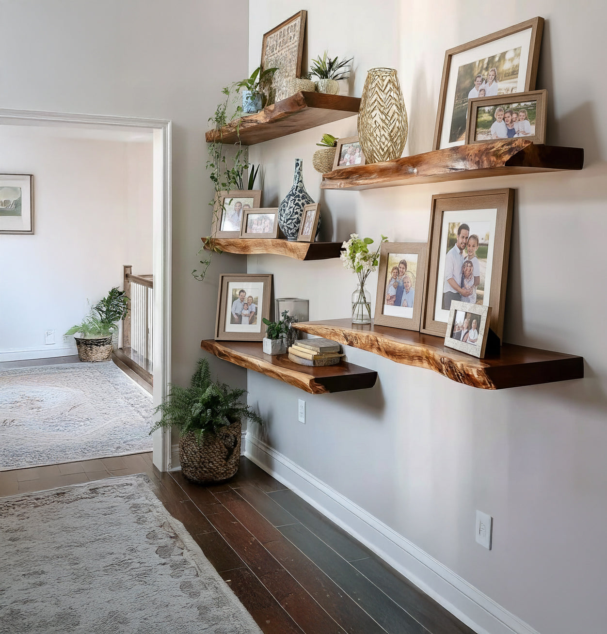 Floating natural wood shelves with family photos, plants, and decorative vases in hallway