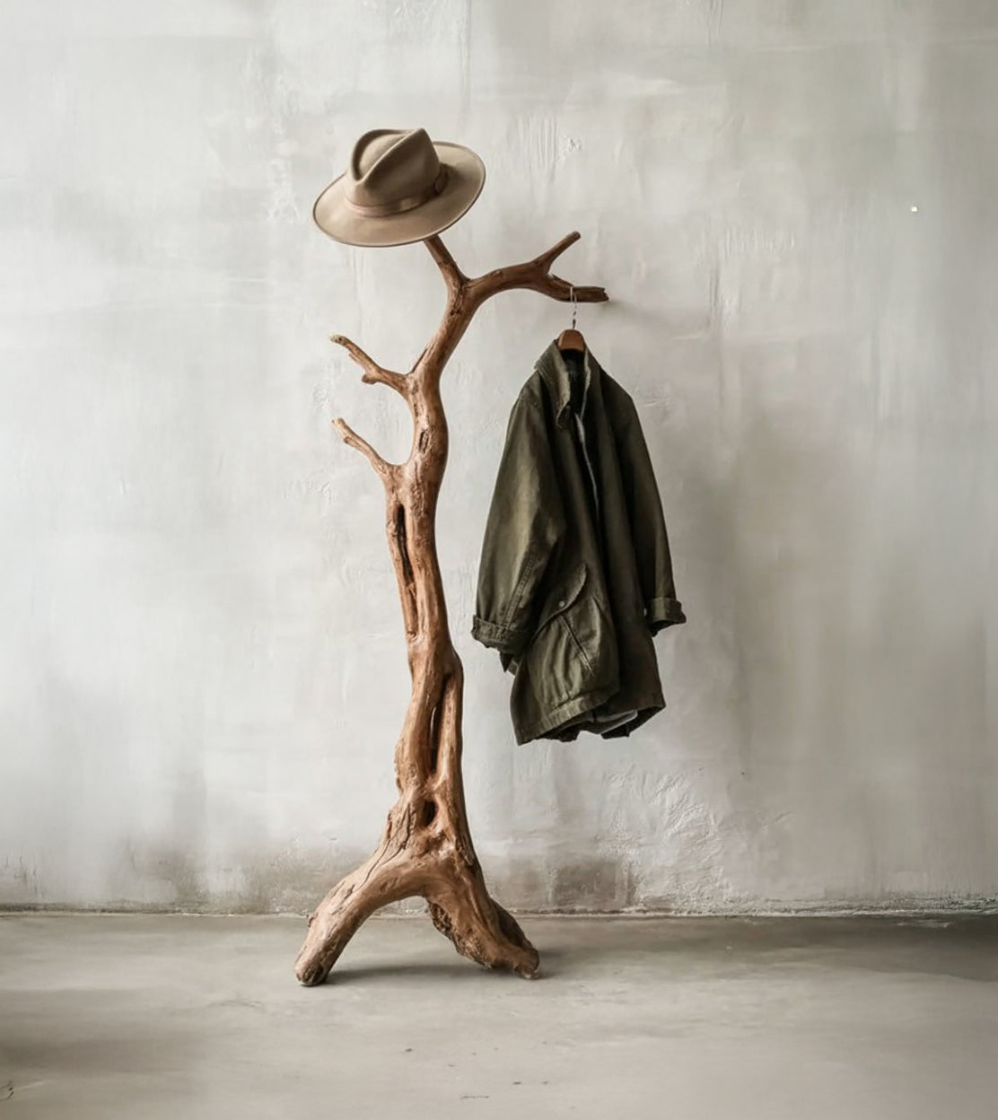 Live edge solid wood coat rack with natural branch design, holding a hat and jacket