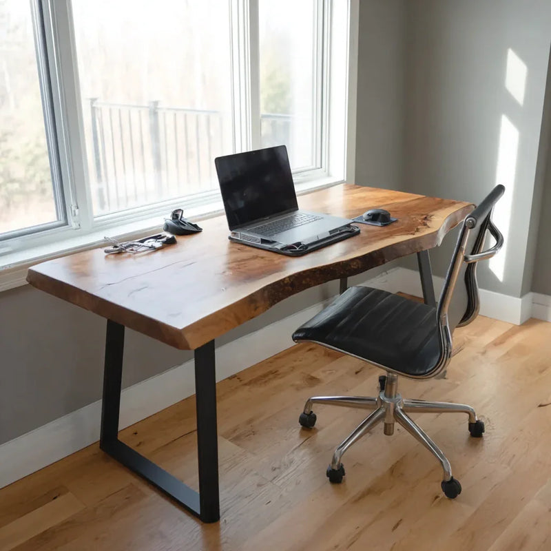 Modern home office setup with live edge wooden desk, laptop, ergonomic chair by large windows