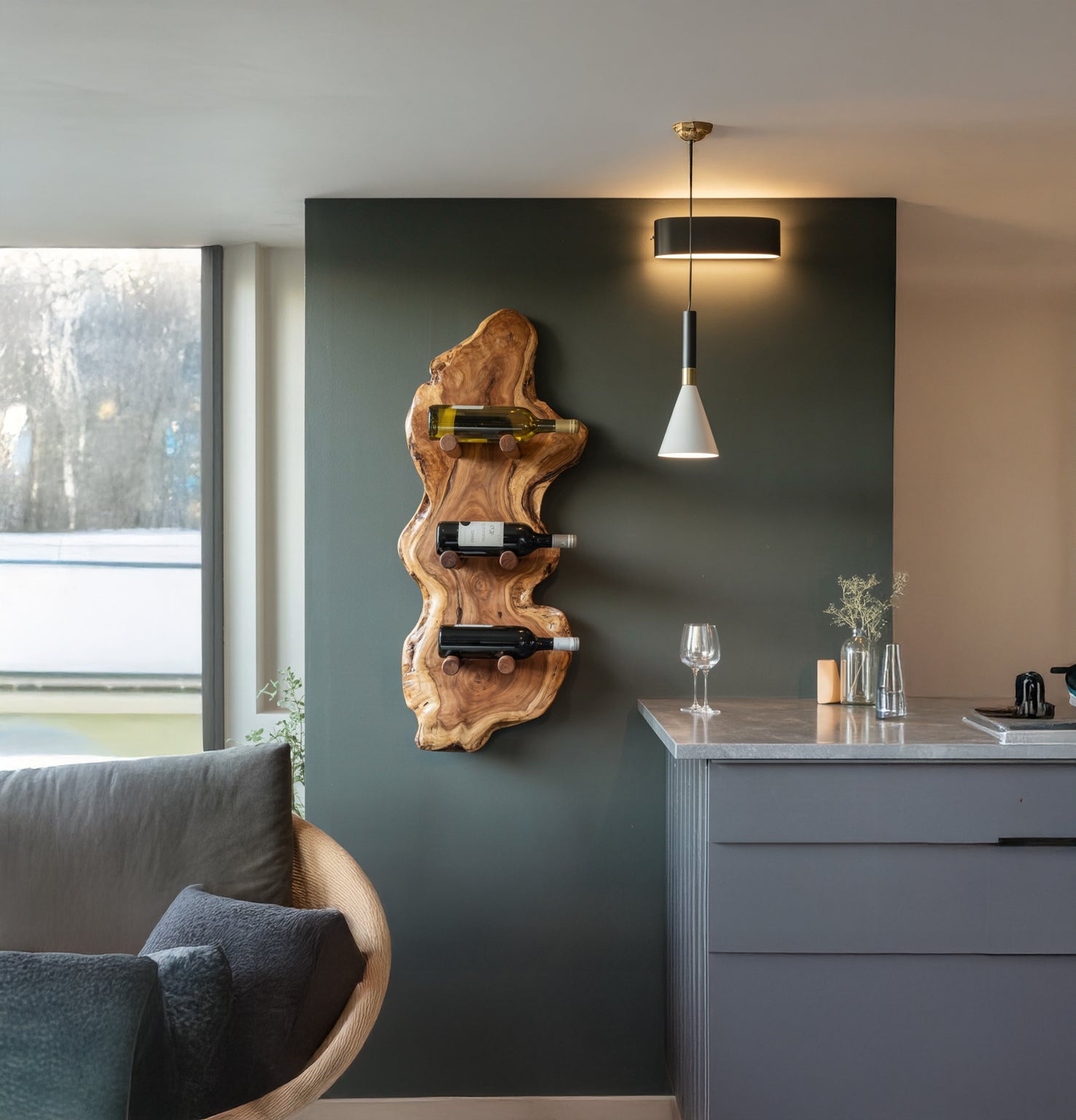 Modern living space with natural wood wall-mounted wine rack holding three bottles and hanging pendant light