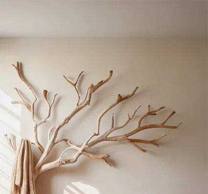Minimalist wooden branch wall decor in bright room with beige towel hanging