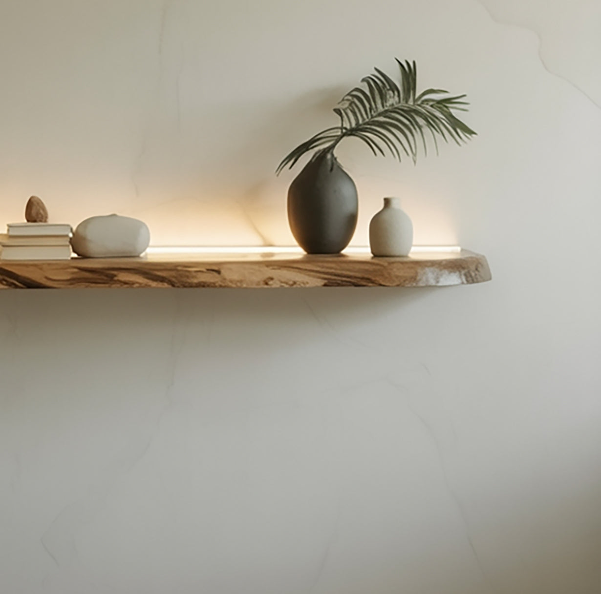Live edge floating wood shelf with minimalist vases, books, and soft wall lighting