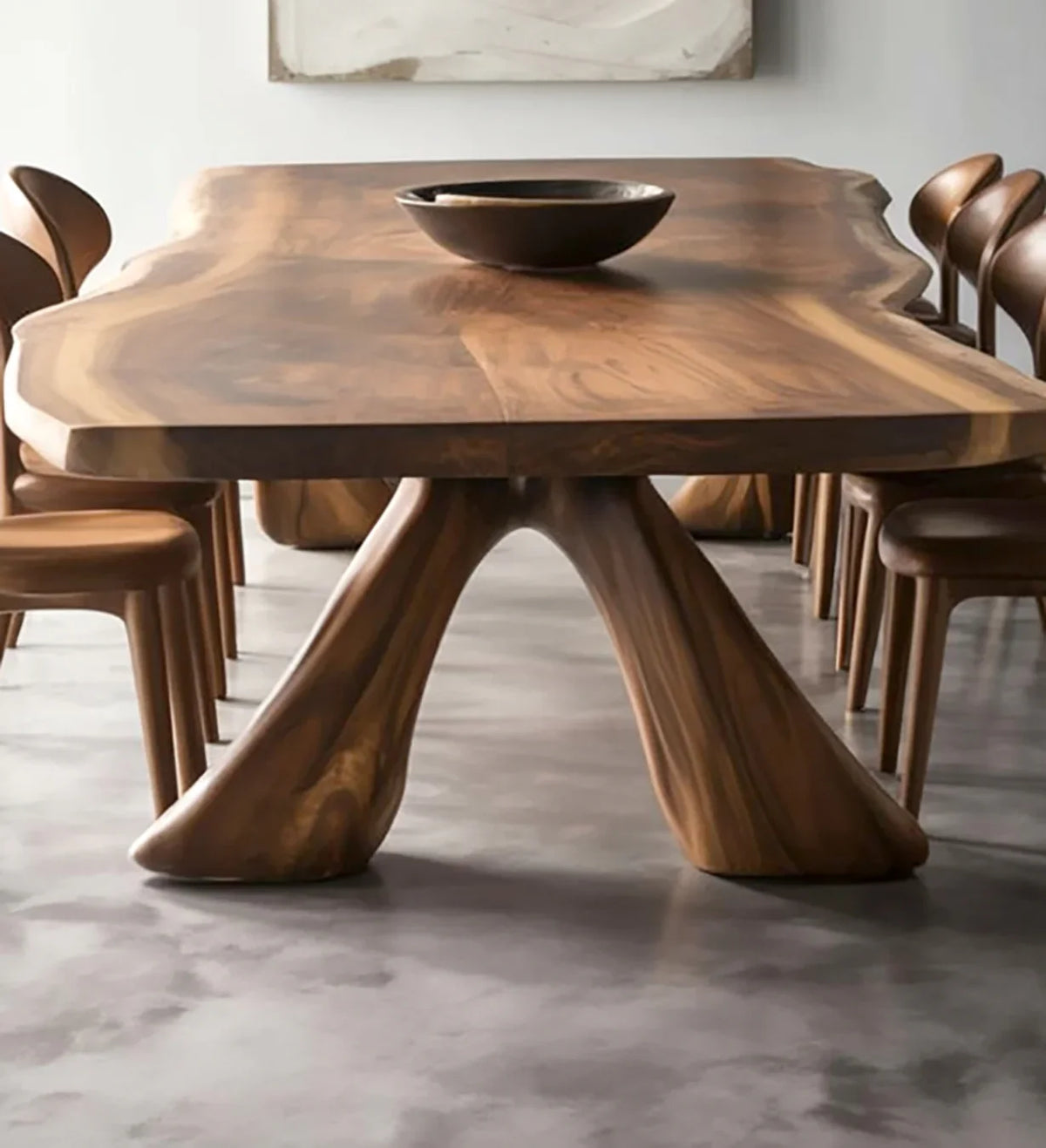 Live edge wooden dining table with sculptural base and matching wood chairs on concrete floor