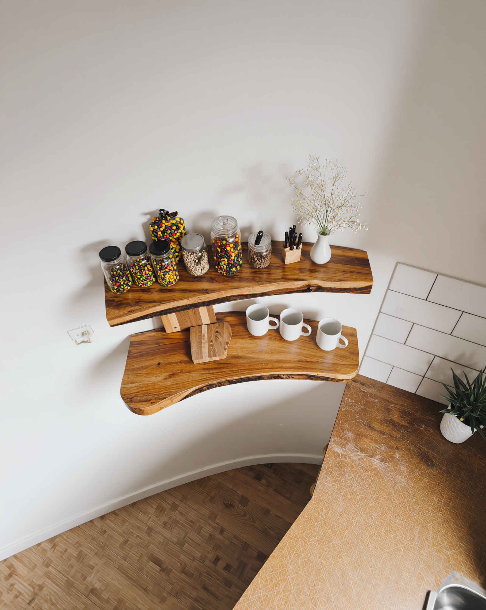Live edge solid wood floating shelves in kitchen with mugs, jars, and vase decor
