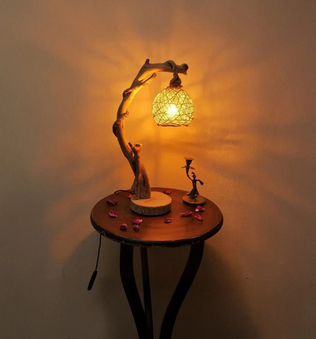 Rustic wooden table lamp with woven shade, lit and placed on a round wooden side table