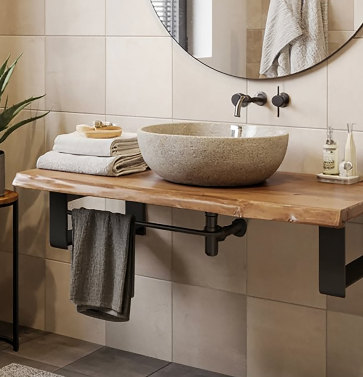 Modern bathroom with stone vessel sink on wood countertop and round mirror