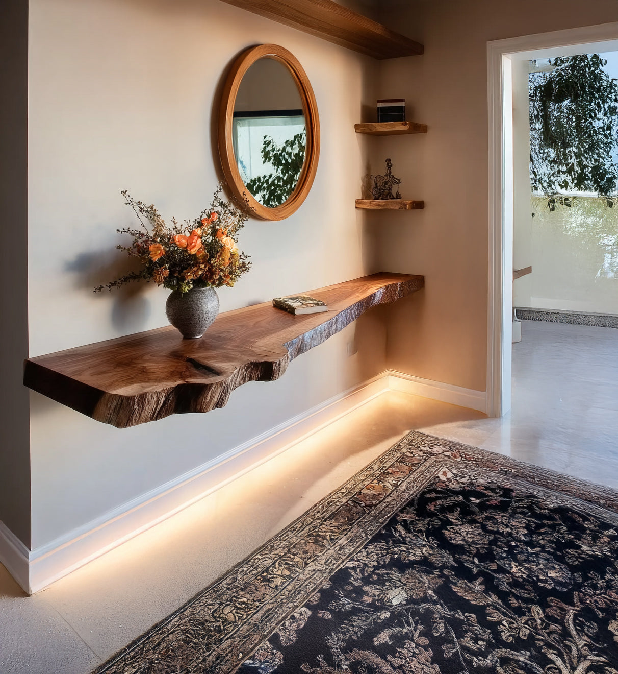 Rustic wooden floating shelf with flower vase and book, round mirror, illuminated baseboard, and patterned rug