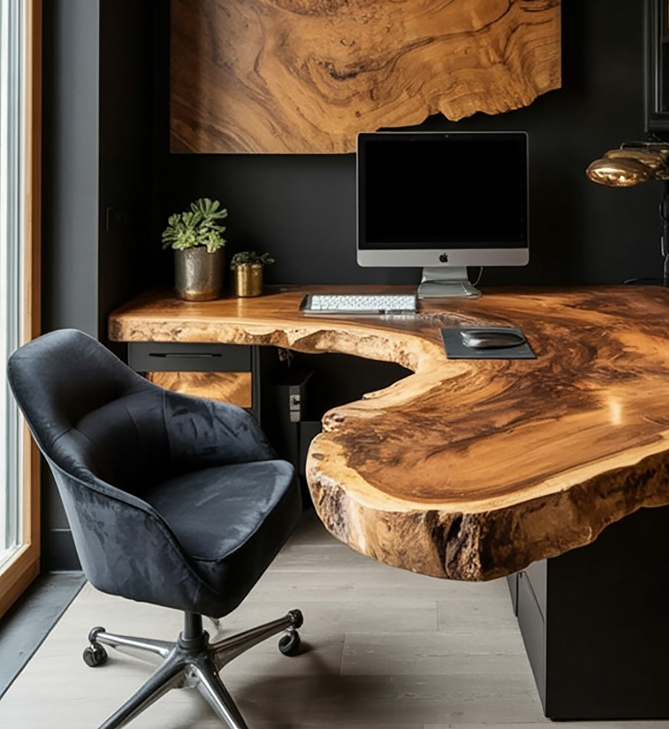 Live edge solid wood desk in modern office with computer, black chair, and potted plants.