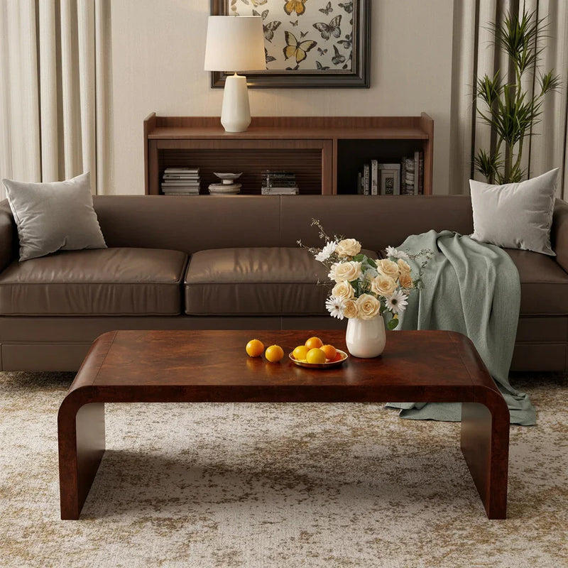 Modern living room with brown leather sofa, wooden coffee table, white flower vase, and butterfly wall art
