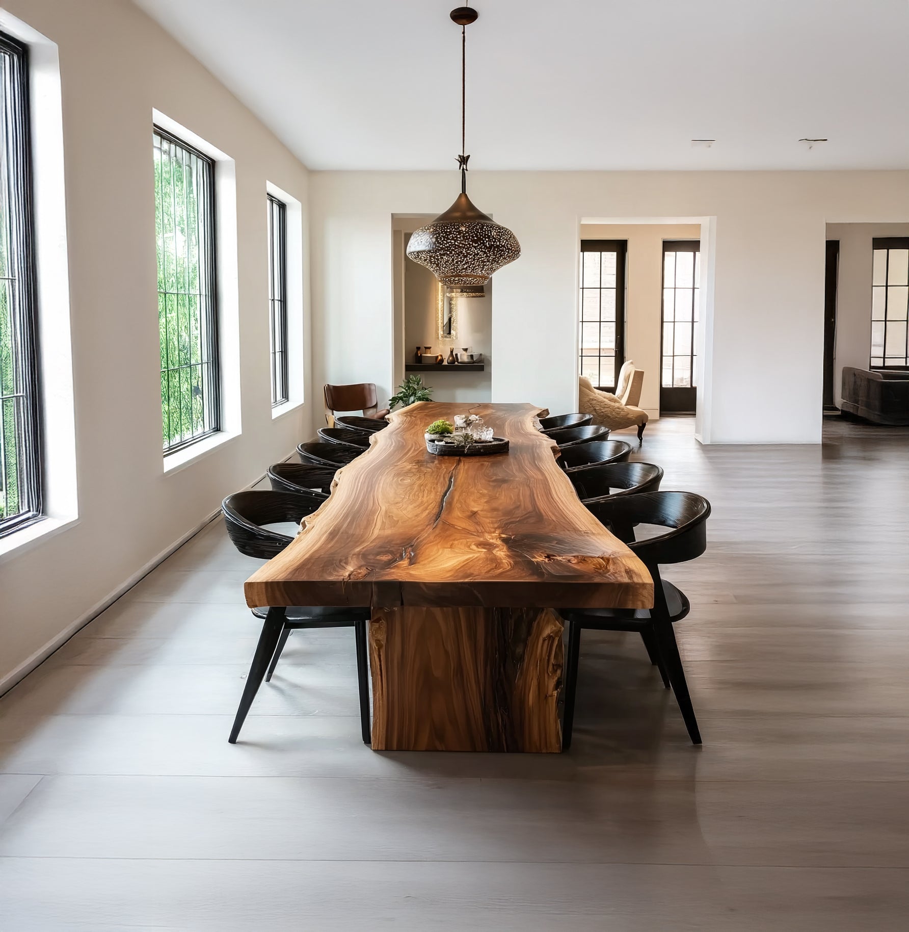 Modern dining room with live edge wooden table, black chairs, large windows, and decorative pendant light