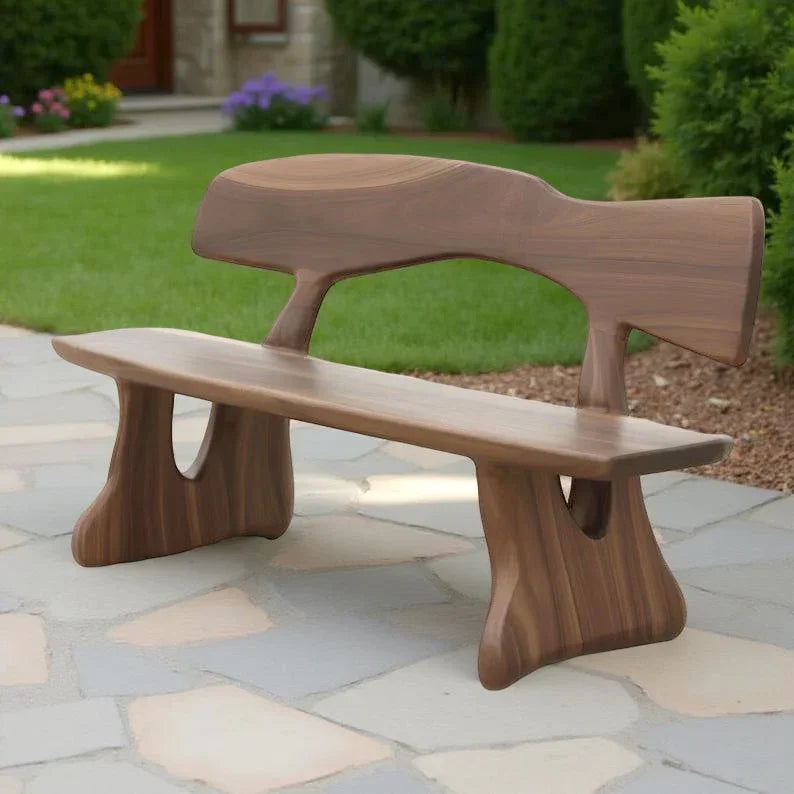Handcrafted solid wood live edge bench with unique sculpted design on a stone patio