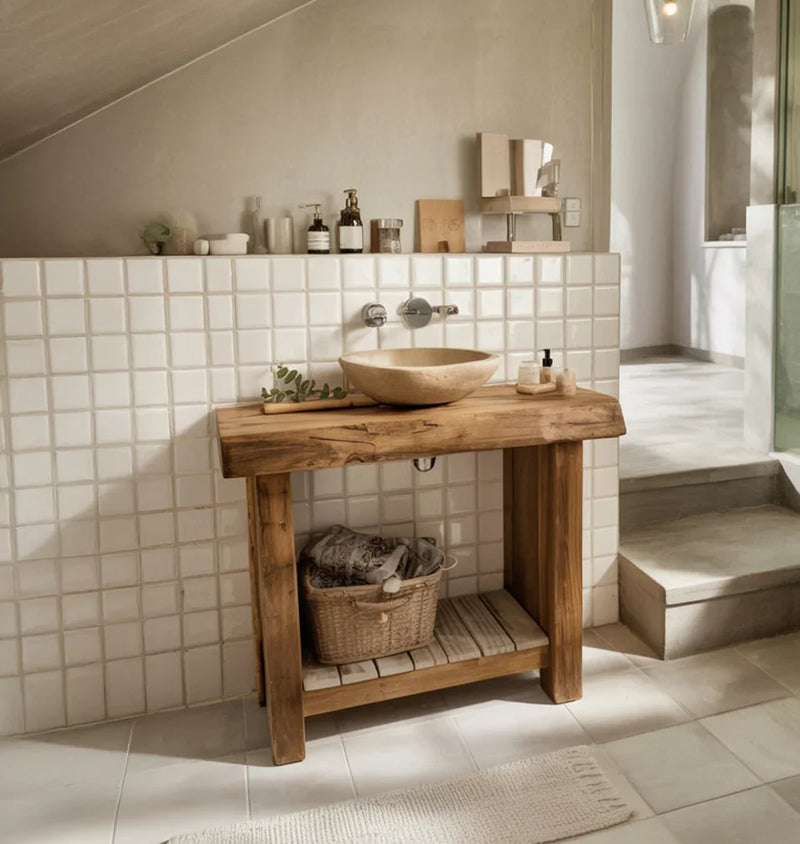 Rustic wooden bathroom vanity with stone vessel sink, white tiled wall, and wicker basket under sink