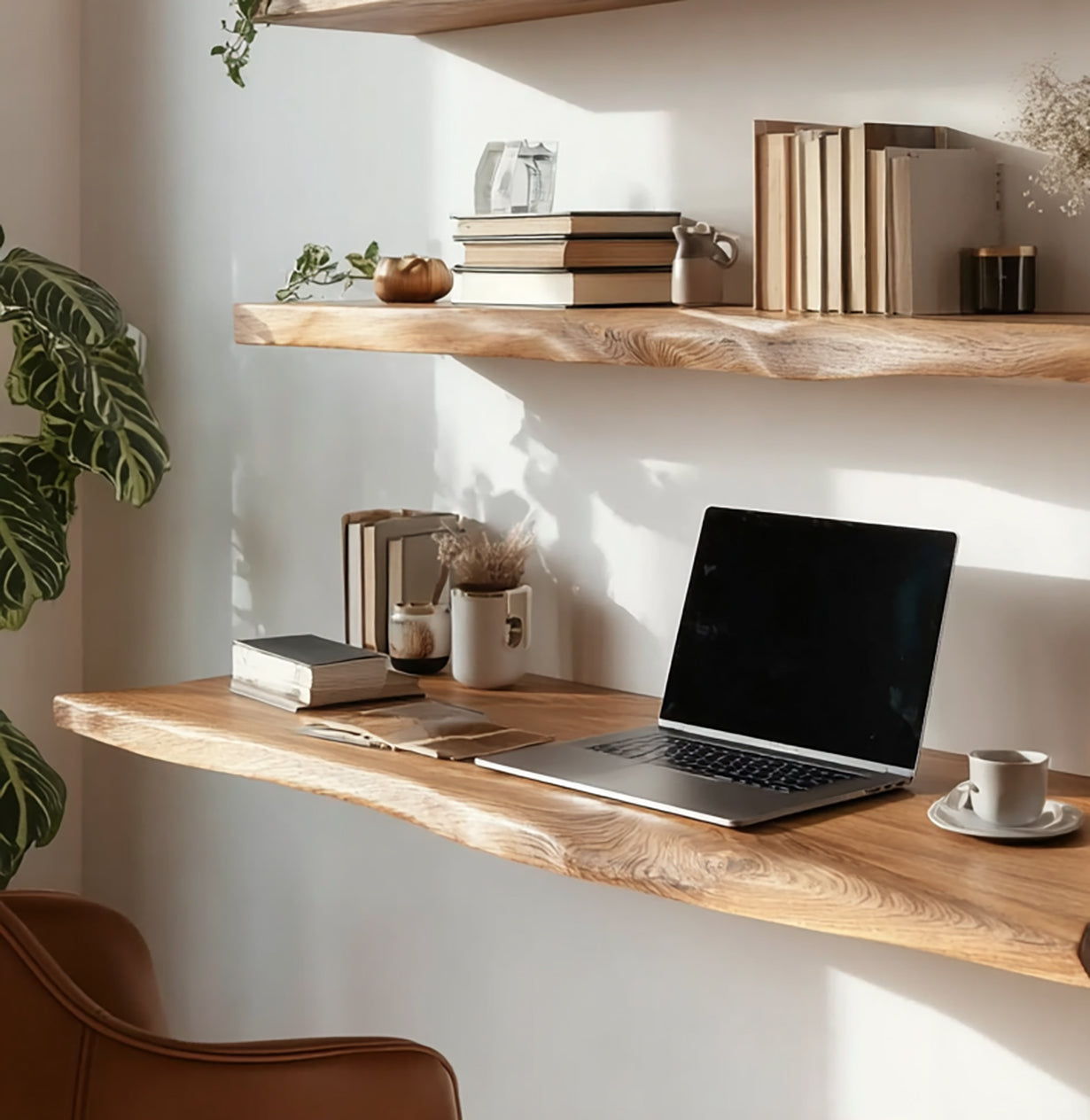 Minimalist wooden floating desk and shelf with laptop, books, plants, and coffee cup in natural light