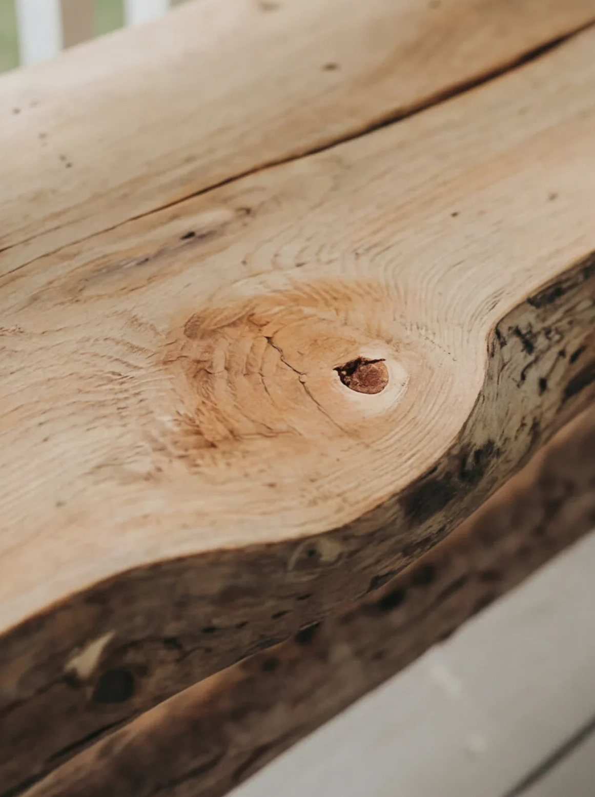 Close-up of a live edge solid wood surface with visible natural grain and knot detail