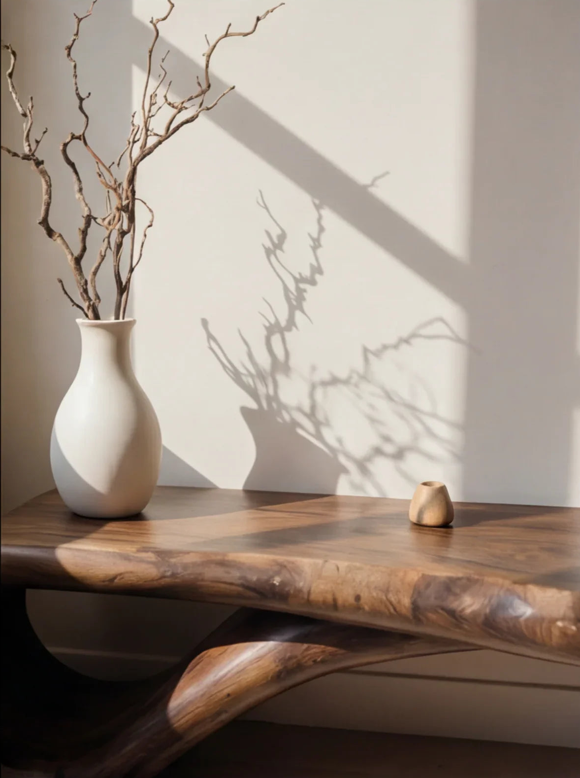 Solid wood live edge table with ceramic vase and branch decor in natural light