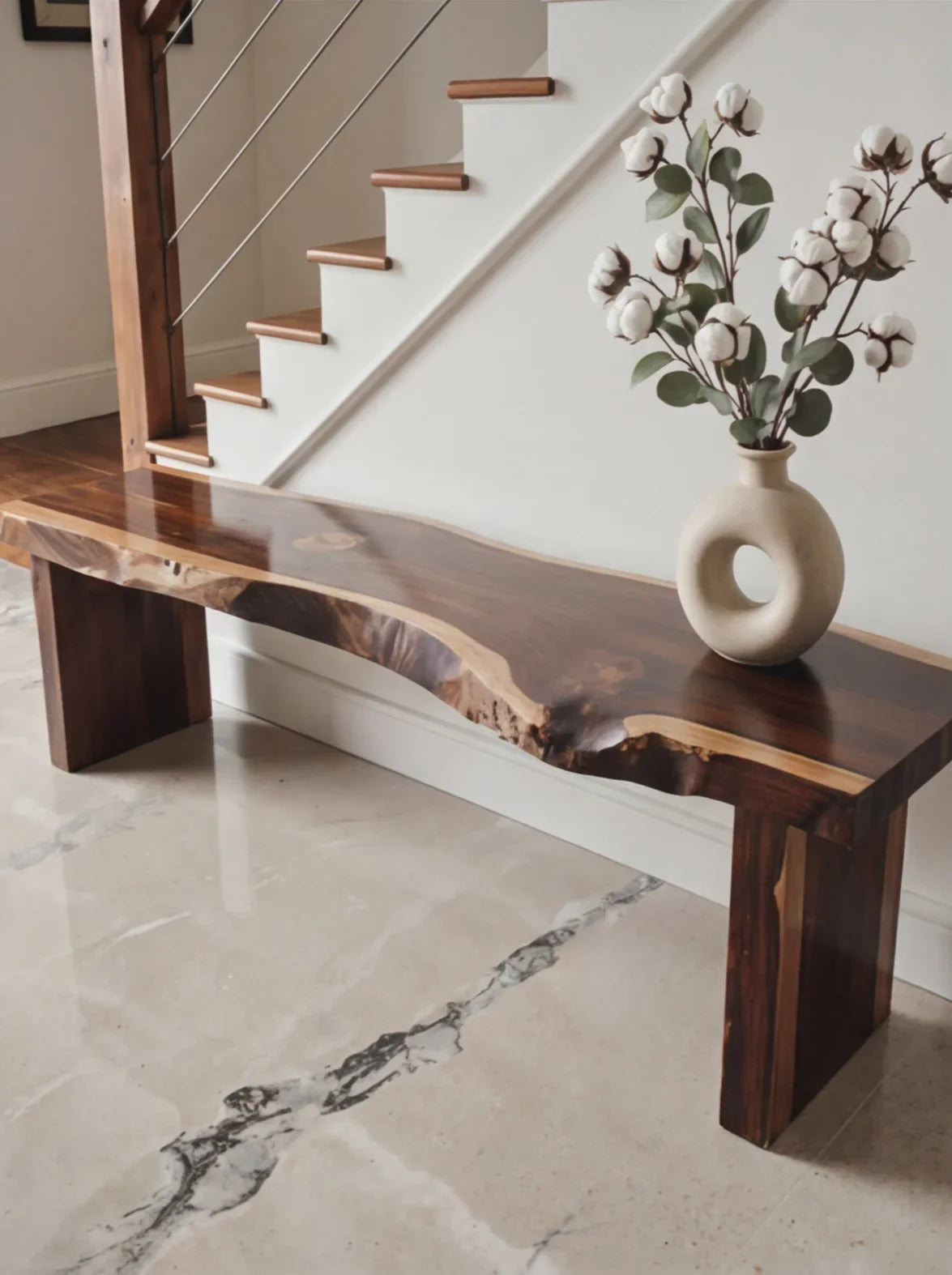 Live edge solid wood bench with decorative vase, placed in modern hallway interior
