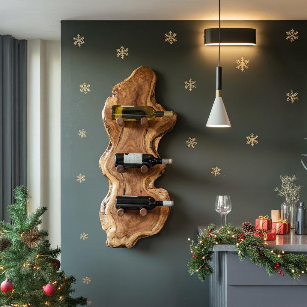 Rustic wood wine rack with three bottles on dark green wall decorated with gold snowflakes in festive room