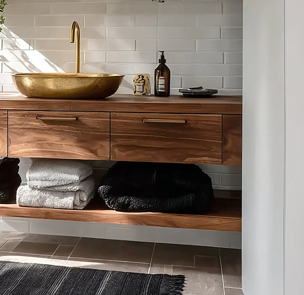 Solid wood floating bathroom vanity with gold vessel sink, towels, and modern decor