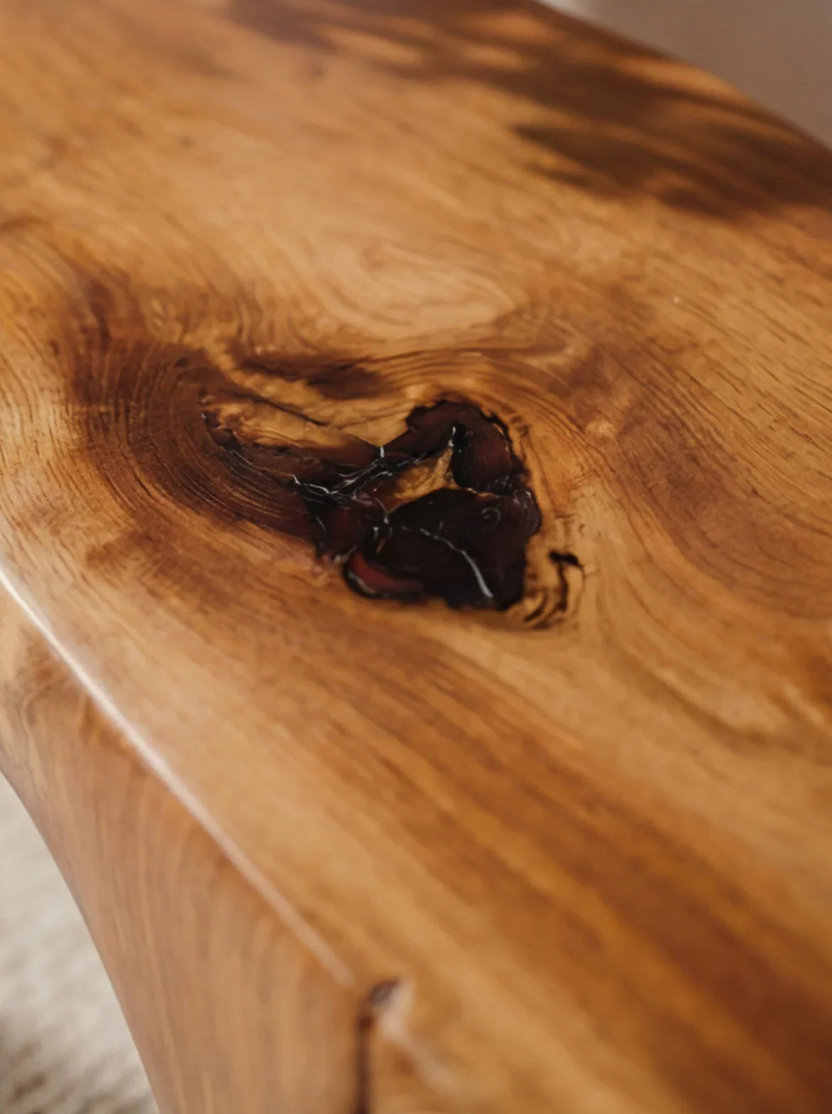 Close-up of sustainably crafted live edge solid wood table with natural grain and knot detail