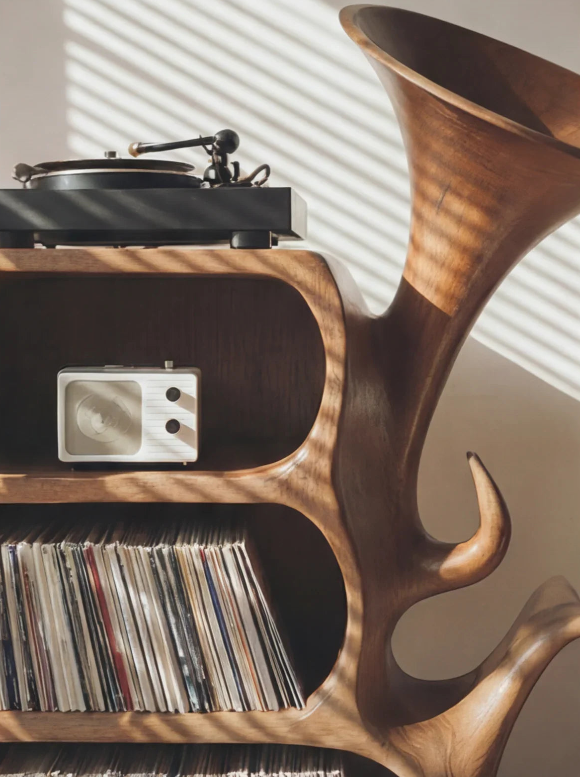 Sculpted solid wood record cabinet with horn detail, turntable, radio, and vinyl records