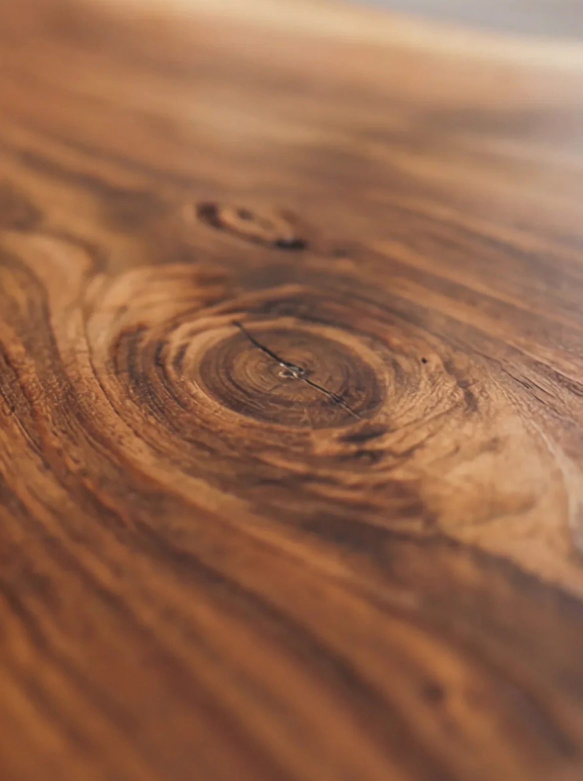 Close-up of live edge solid wood table with natural wood grain and knot detail