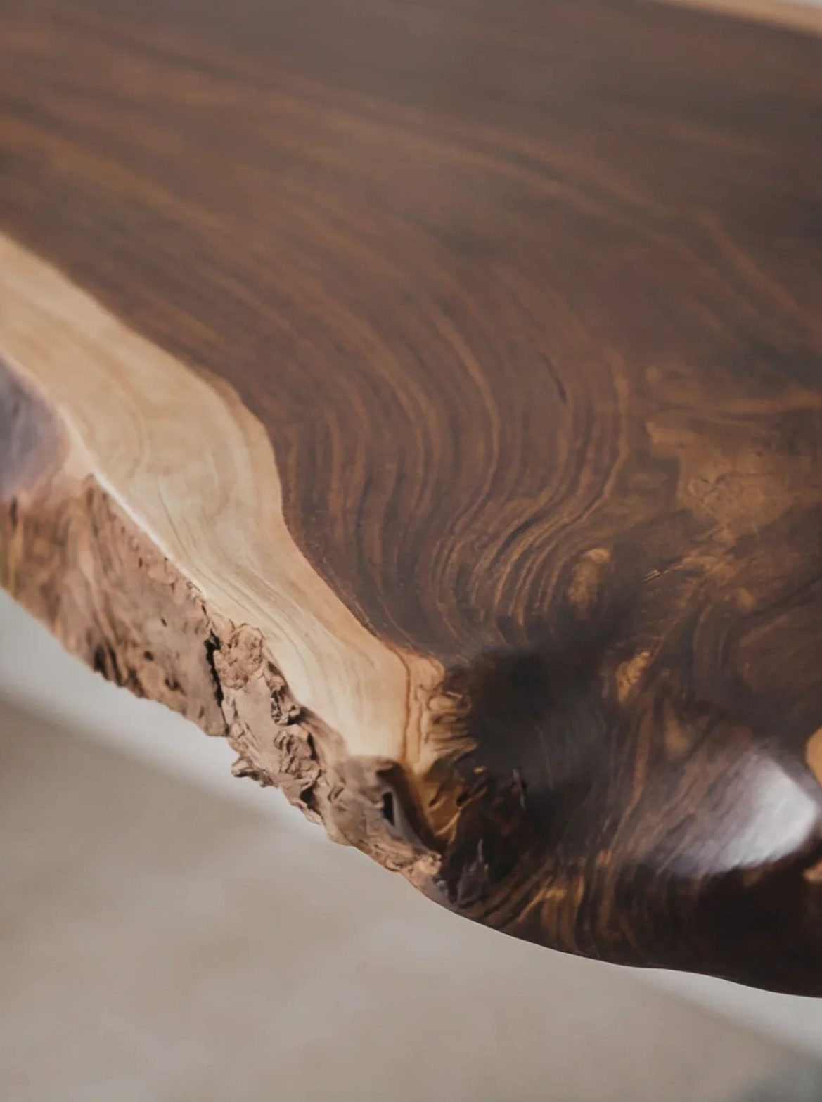Close-up of live edge solid wood table with natural grain and rustic finish