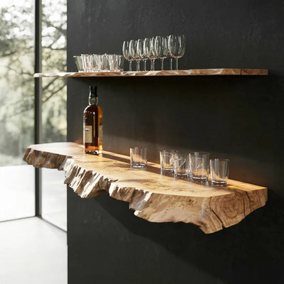 Live edge floating wood shelves on black wall, with glassware and bottle displayed.