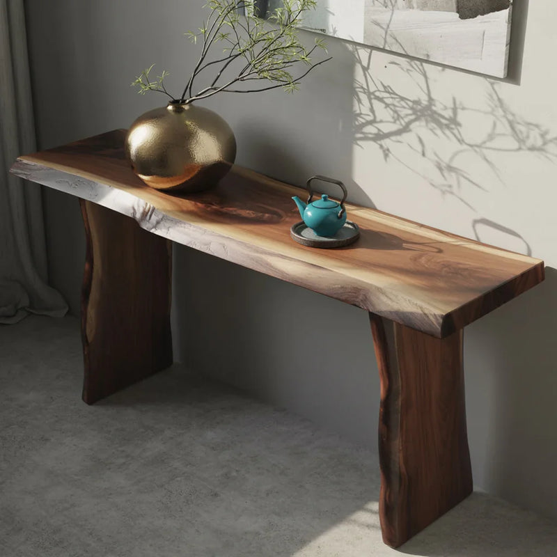Live edge solid wood console table with a gold vase and teal teapot in modern interior