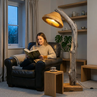 Woman reading under arc floor lamp with driftwood stand and mushroom-shaped cap