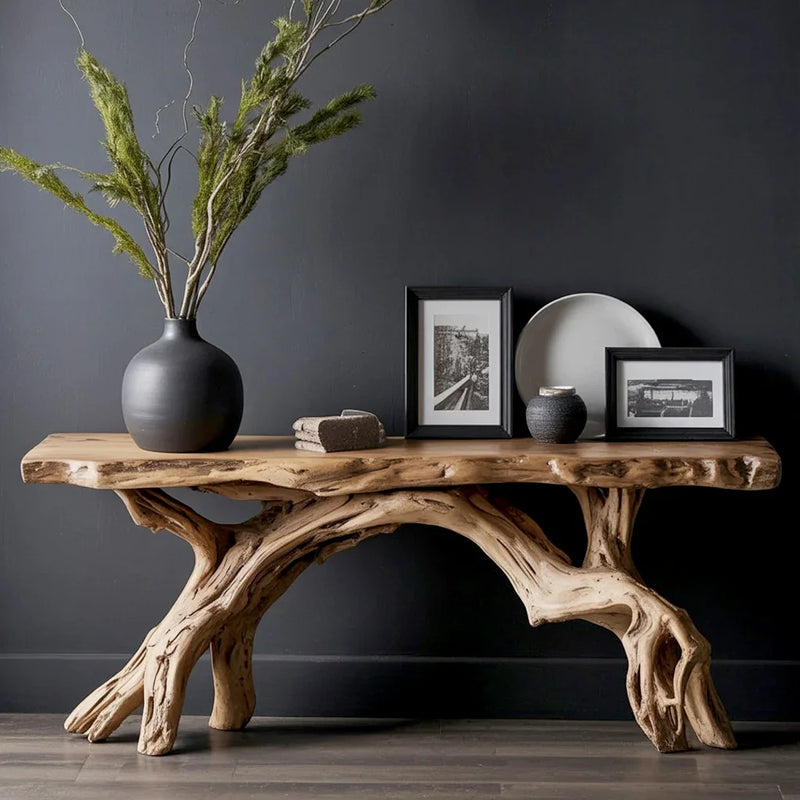 Rustic wooden console table with natural branch legs, black vase with greenery, framed photos, and decor