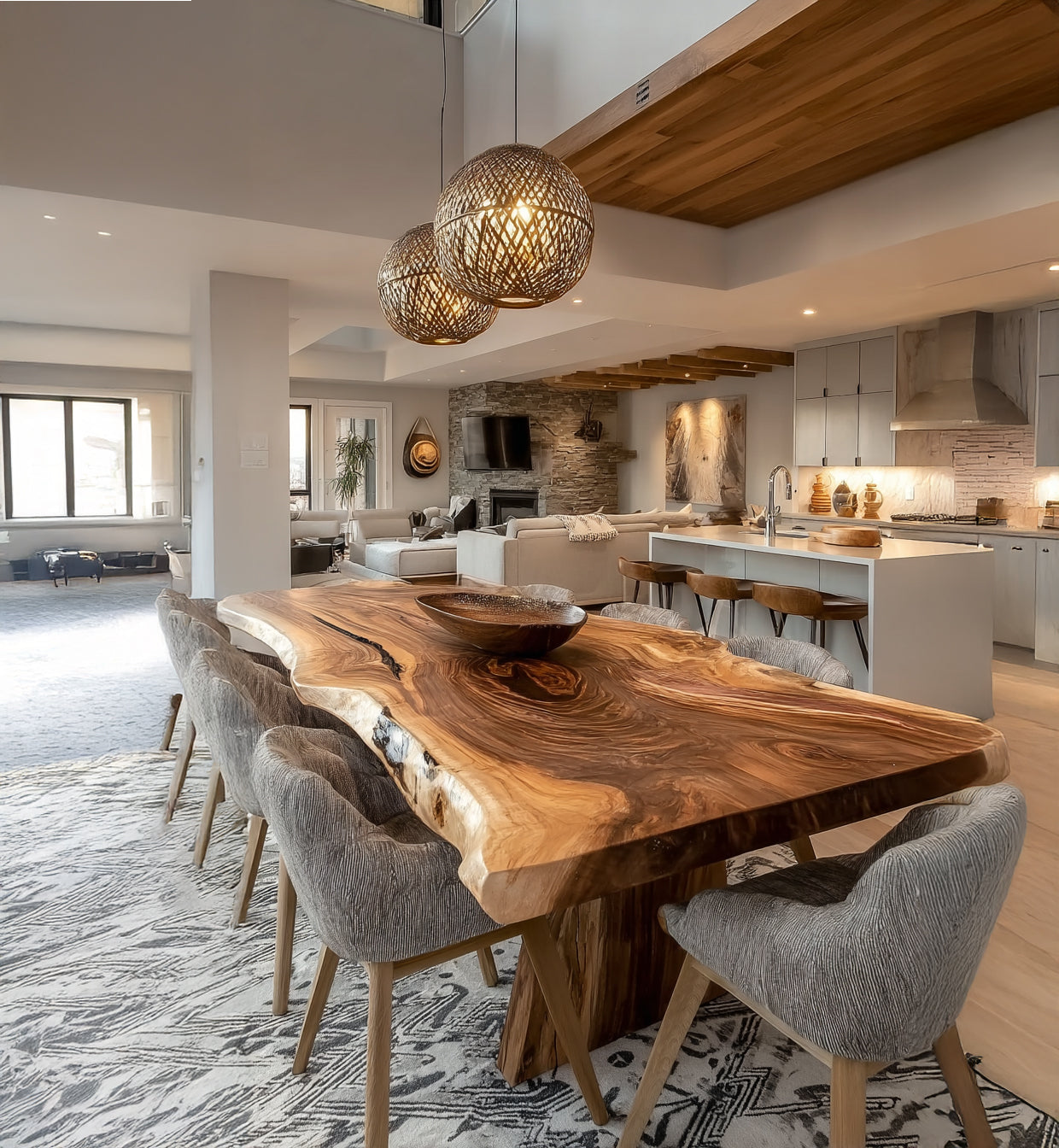 Modern open-concept dining and living area with live edge wood dining table, gray upholstered chairs, and woven pendant lights