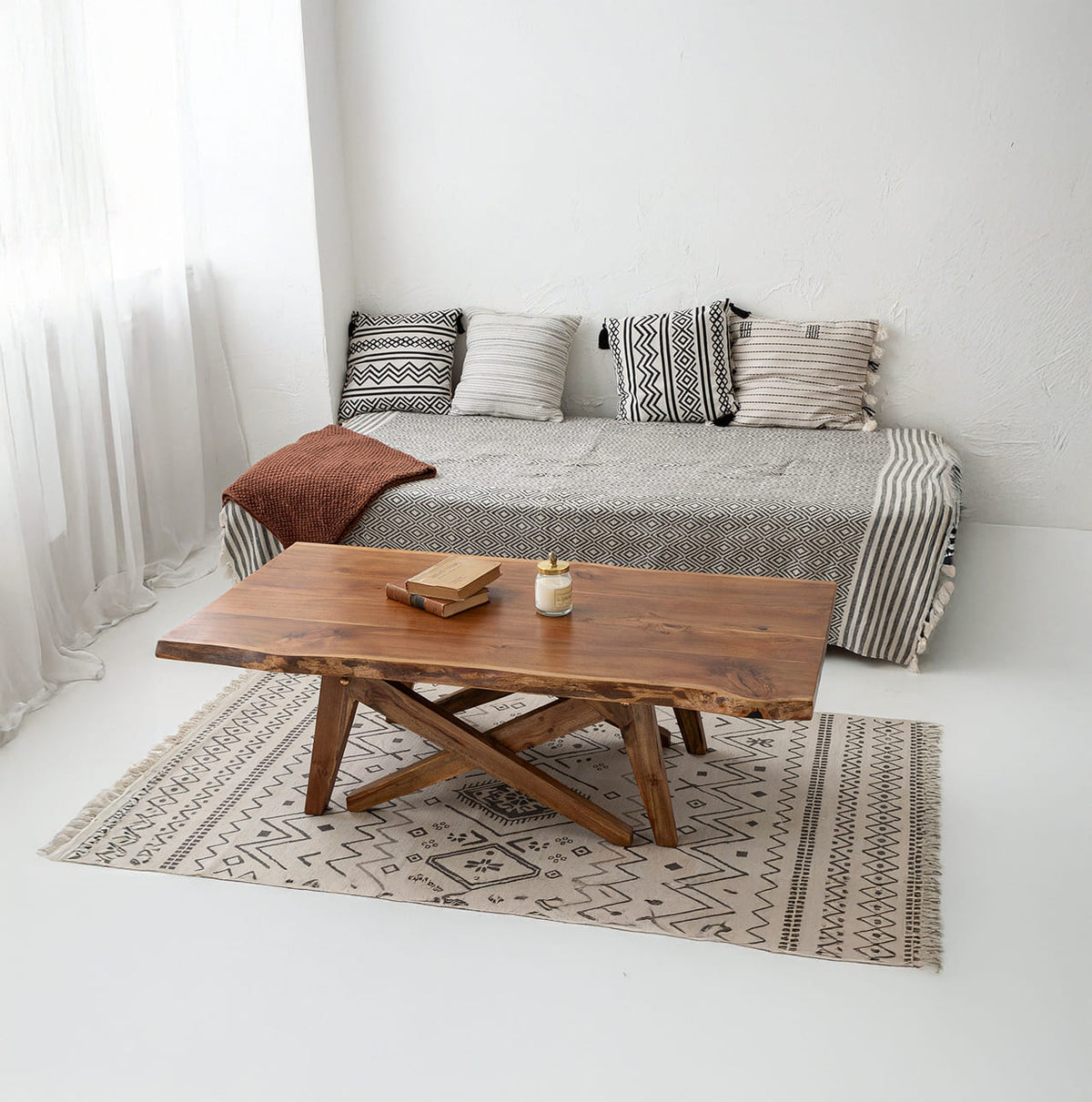 Handcrafted solid wood coffee table with X-base displayed in a contemporary living room