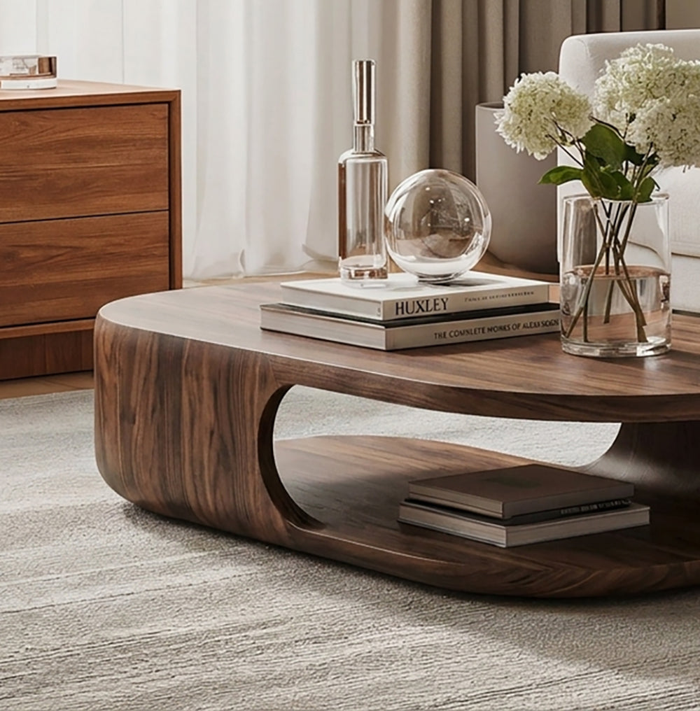 Curved solid wood coffee table featuring an open lower shelf for storage and display
