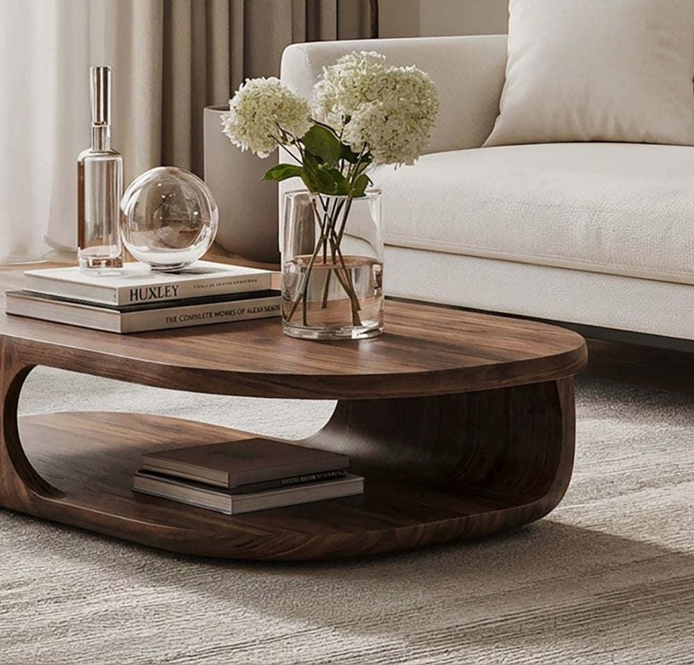 Curved solid wood coffee table featuring an open lower shelf for storage and display