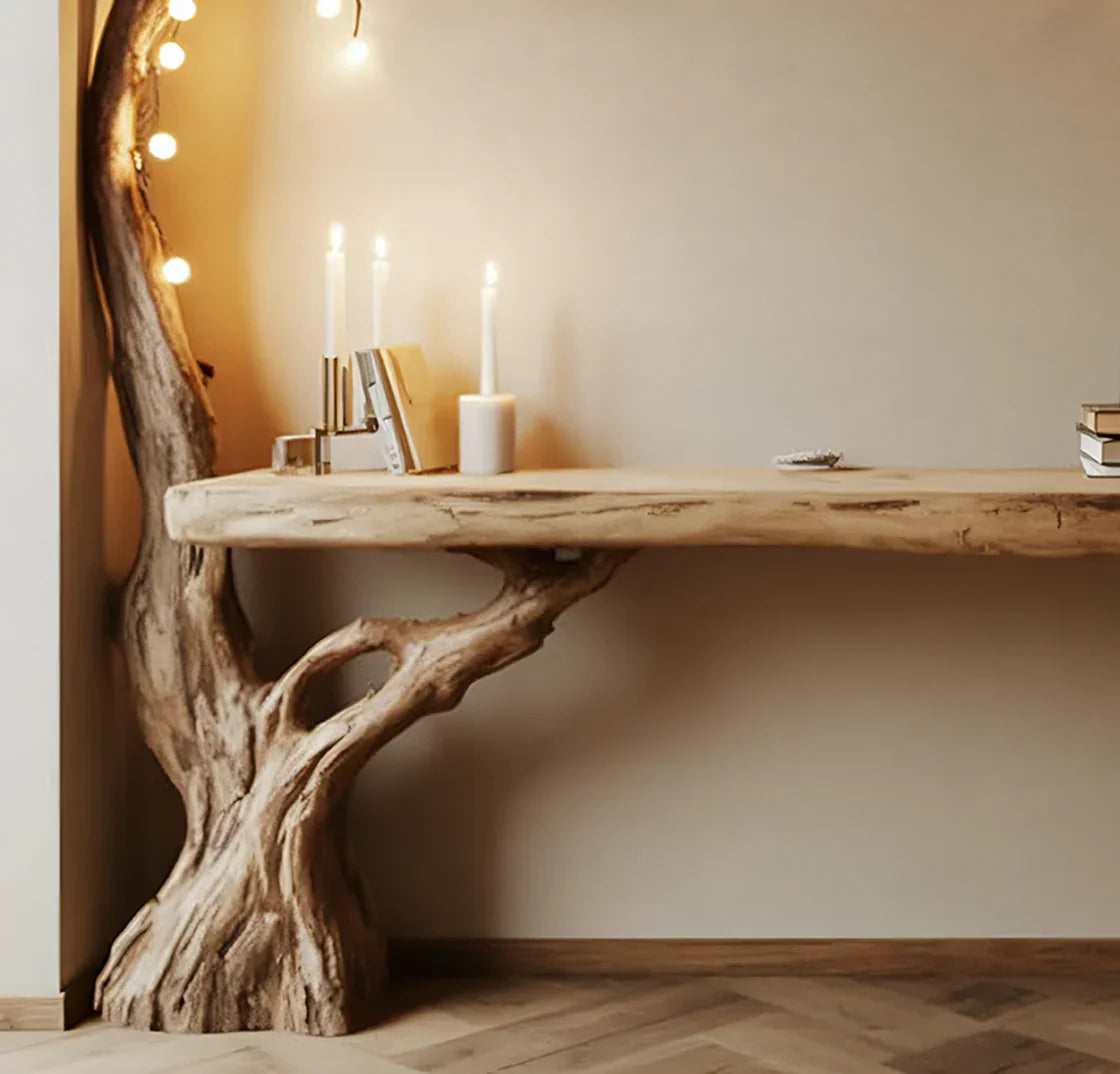 Live edge wood console table with tree trunk base, candles, books, and warm fairy lights