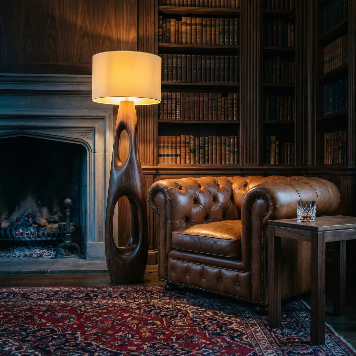 Carved wood floor lamp with dual openings beside a leather armchair in a vintage study