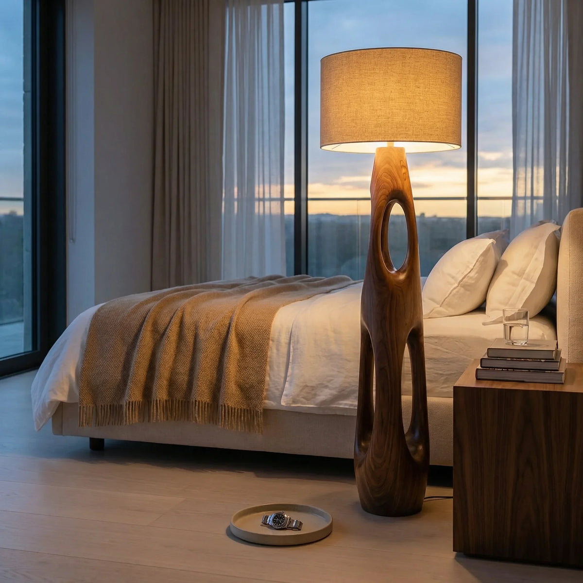 Carved solid wood floor lamp with dual openings in modern bedroom by window at sunset