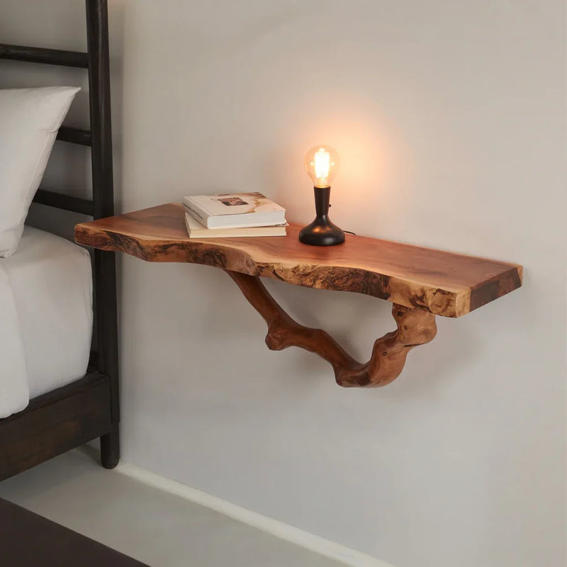 Live edge solid wood floating shelf with modern lamp and books in a bedroom setting