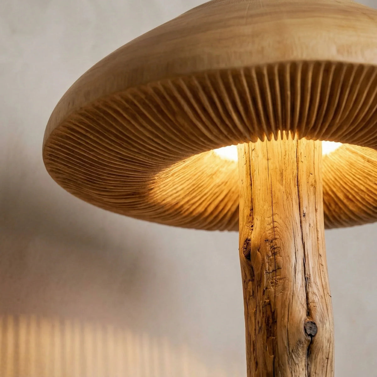 Wide parasol mushroom-inspired floor lamp with hand-carved wood gills and log stem lit up